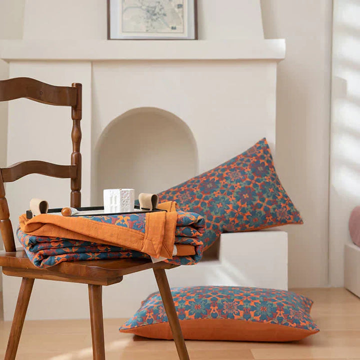 Unisex six-layer cotton quilt draped on a bed, showcasing its vibrant orange & blue pattern and comfortable appeal.