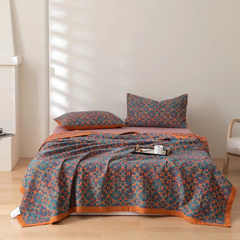 Neatly folded vibrant orange & blue six-layer cotton quilt. Eco-friendly bedding and home decor textile.