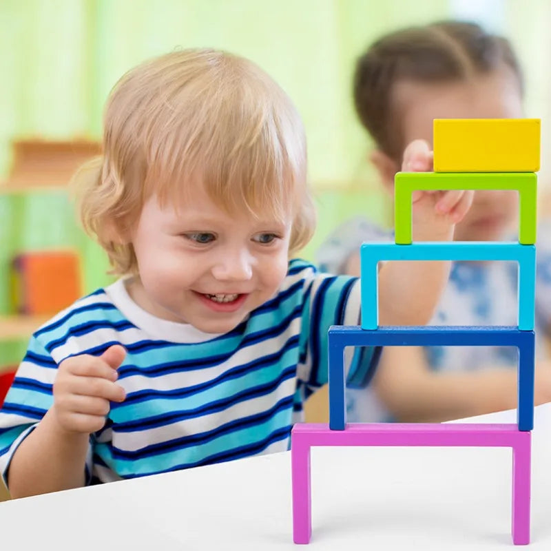 Kids playing with large rainbow wooden stacking blocks, an engaging educational balance game.