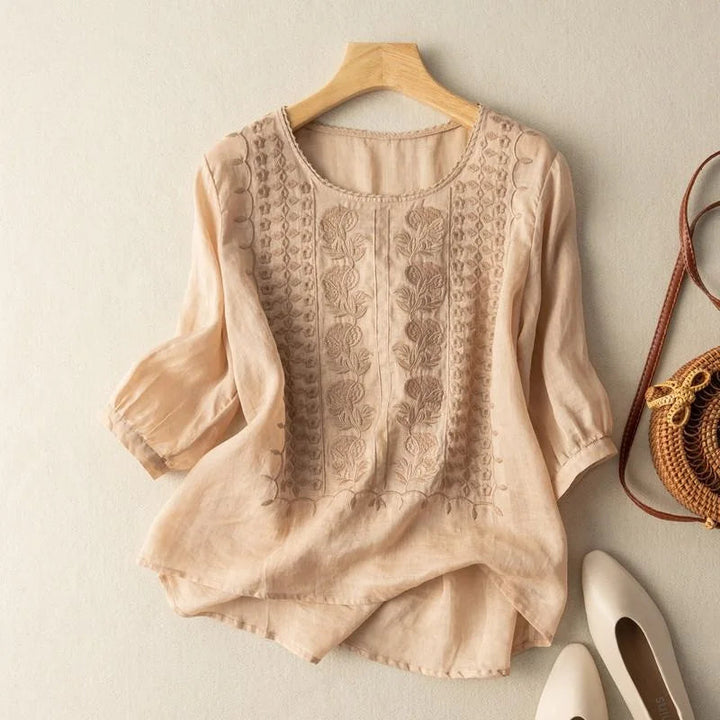 Vintage embroidered women's blouse with delicate floral patterns and sheer puff sleeves, perfect for spring.