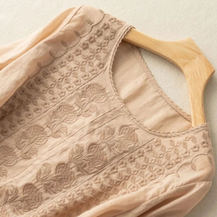 Elegant women's blouse featuring sheer puff sleeves and intricate embroidery, ideal for a chic summer look.
