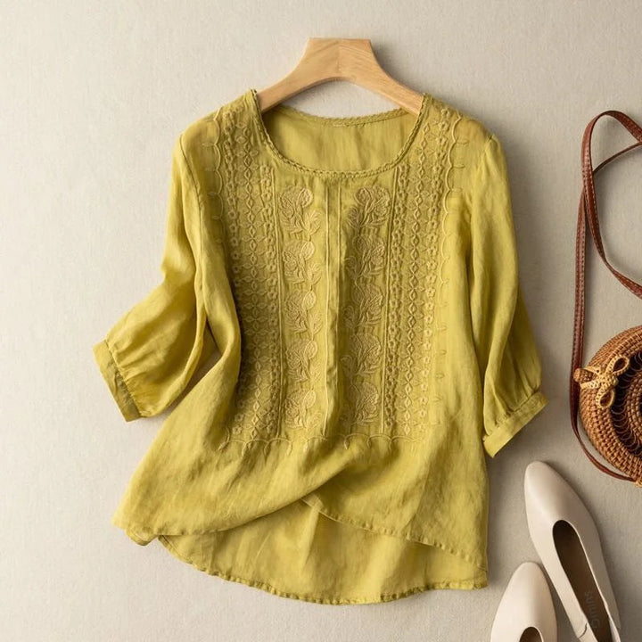 Round neck women's blouse with vintage-inspired embroidery & stylish sheer puff sleeves. Feminine & comfortable.