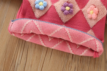 Detailed view of the girls' knitted set, showcasing the vintage design of the pullover and matching skirt.