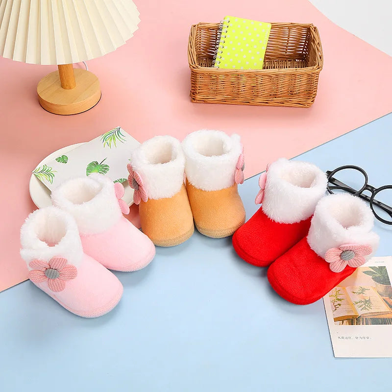 Close-up of knitted fabric baby boots, cozy warm, with cute flower pattern for winter