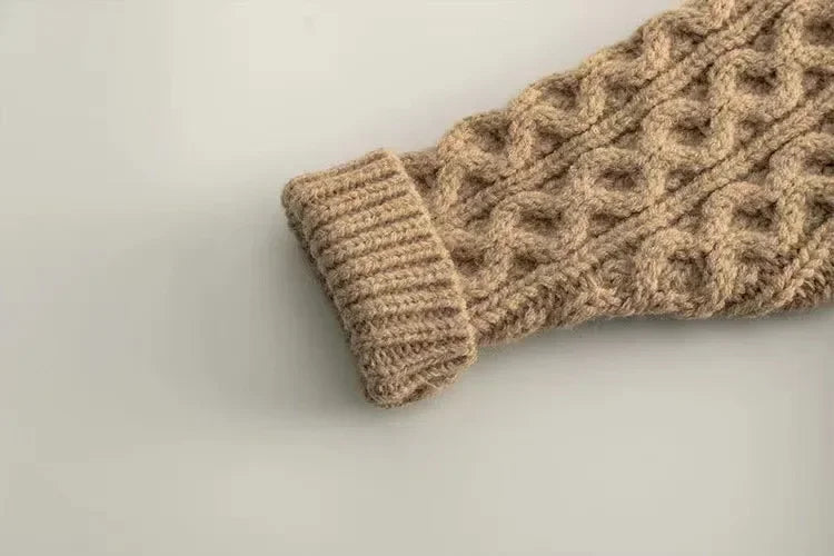 Beige kids' knitted sweater laid flat, showcasing its cozy texture and winter wear design