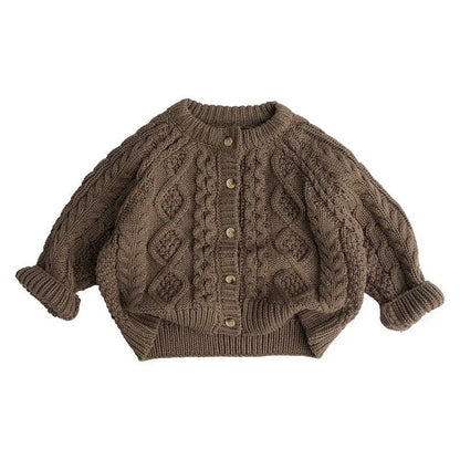 Stack of folded beige and brown knitted sweaters for toddlers, ready for winter fashion