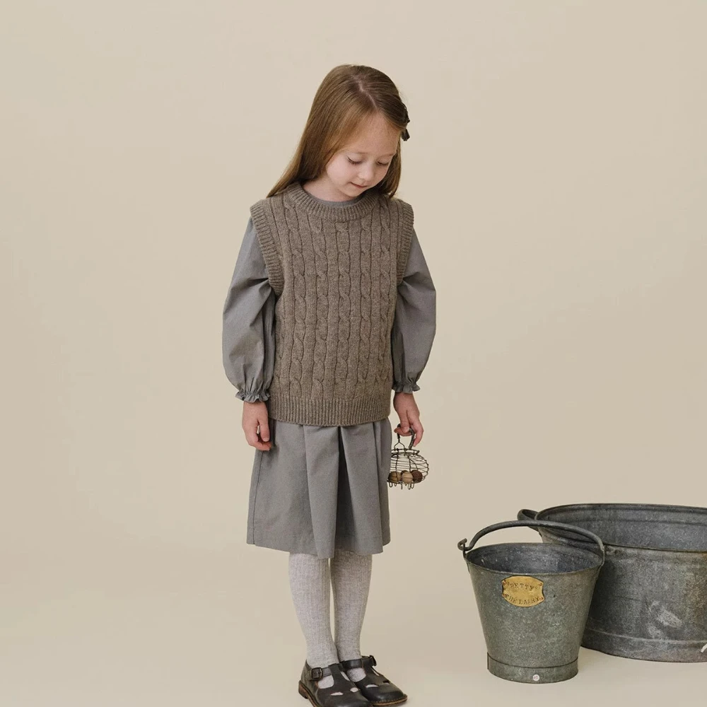 Close-up of a beige wool blend sweater, detailing the soft texture for kids' wear
