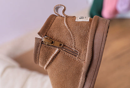 Children's winter ankle boots with cozy faux fur lining in brown. Fashionable kids' footwear.