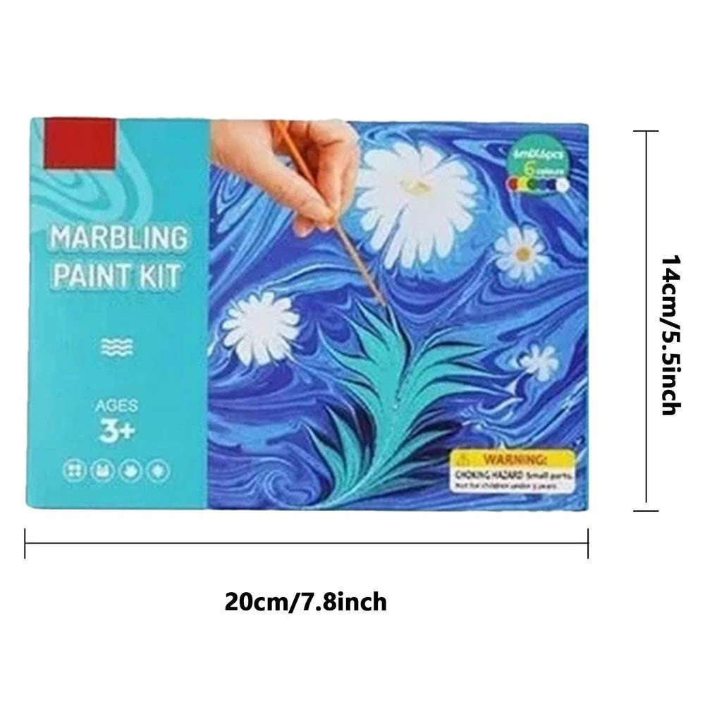 A child's hands carefully dipping paper into marbled water, demonstrating the DIY art process