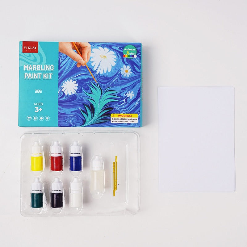 Assorted painting supplies from a water marbling set, including paints, stylus, and paper for liquid art