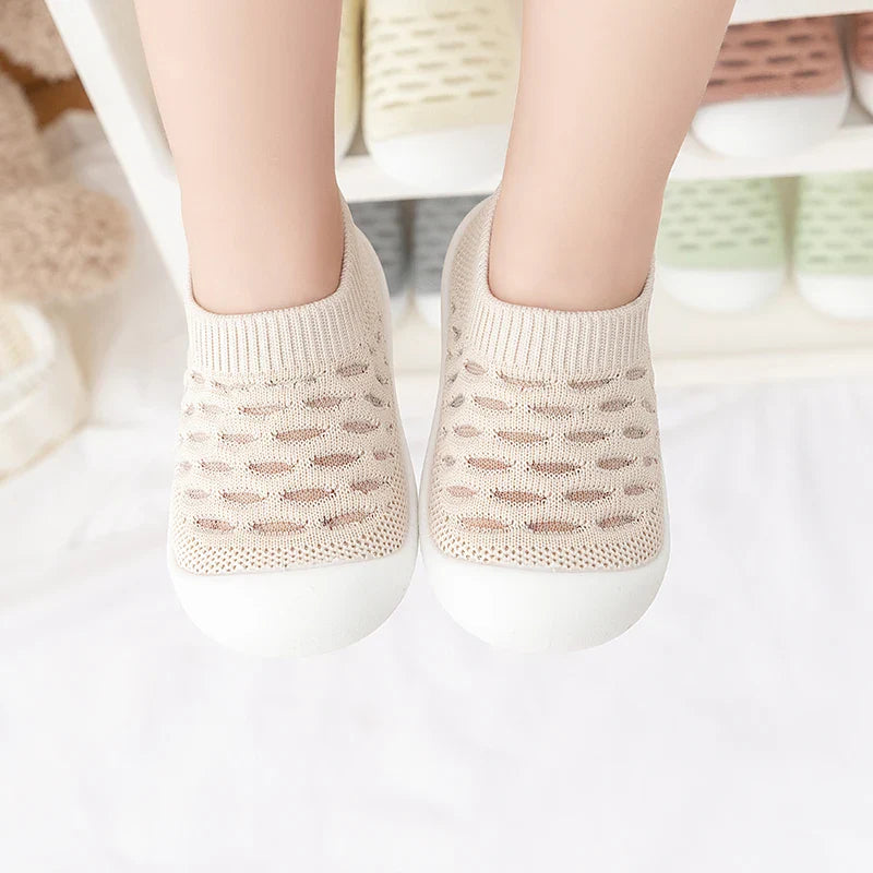 Baby accessories: a pair of breathable mesh sneakers on a soft blanket