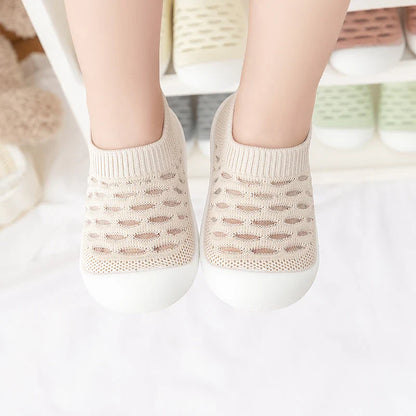 Baby accessories: a pair of breathable mesh sneakers on a soft blanket