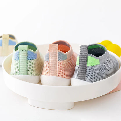 Baby wearing white breathable mesh sneakers, playing on a sunny spring day
