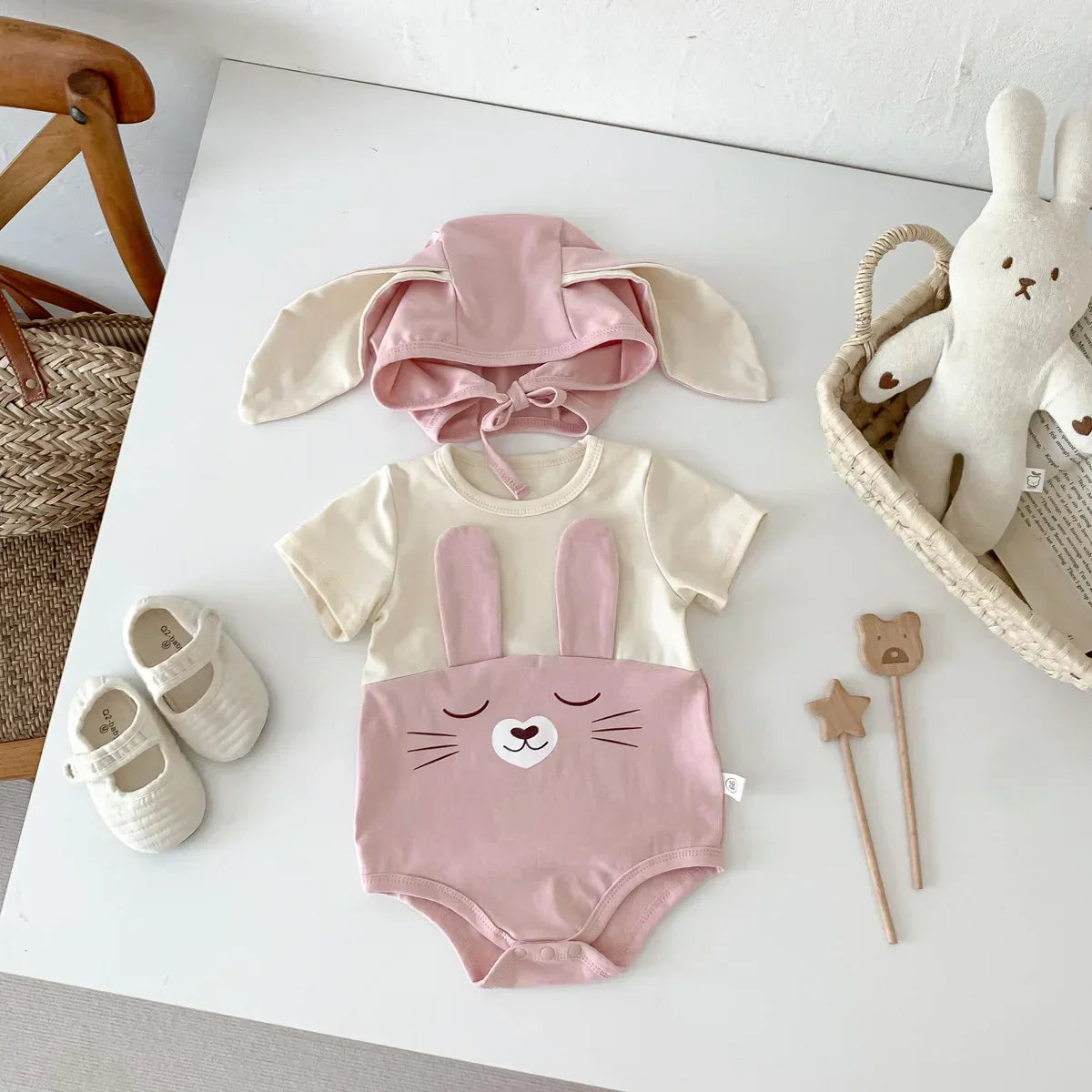 Pack of three white cotton baby bodysuits and caps, essential soft newborn clothing set.