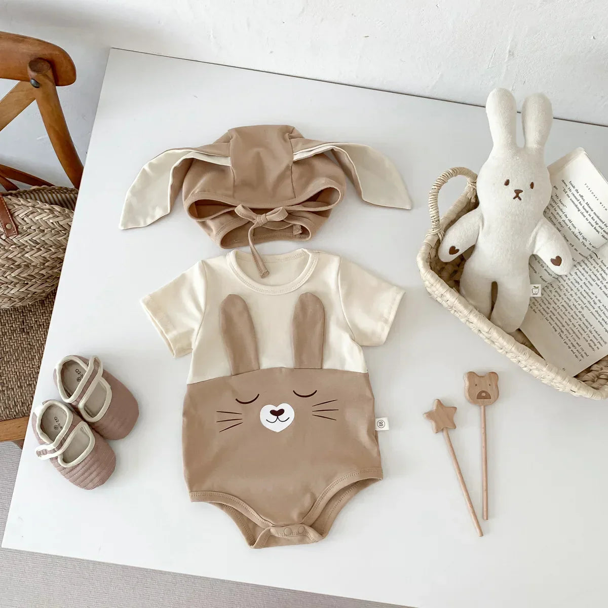 White baby cotton bodysuit onesie with snap closures and matching cap, breathable infant wear.