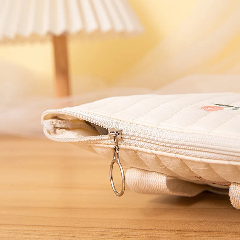 Baby cotton diaper bag in a lifestyle setting, being carried by a parent, baby travel essential