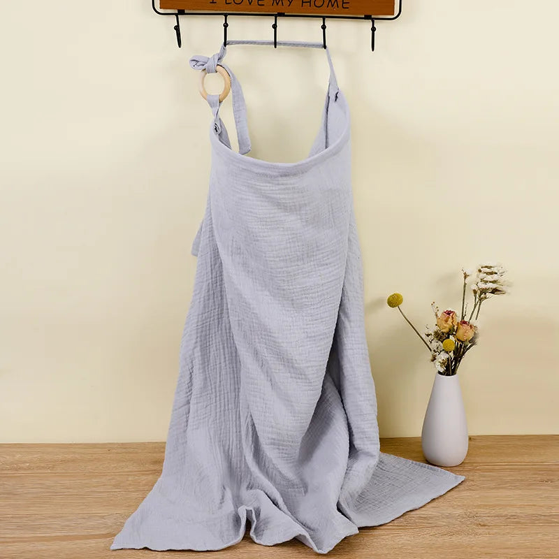 Baby sleeping soundly under a breathable cotton muslin stroller blanket.
