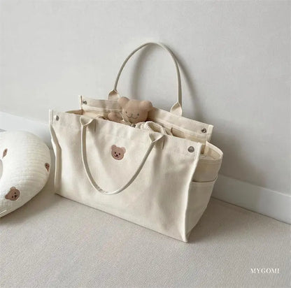 White canvas baby essentials bag, with sturdy construction and clean aesthetic.