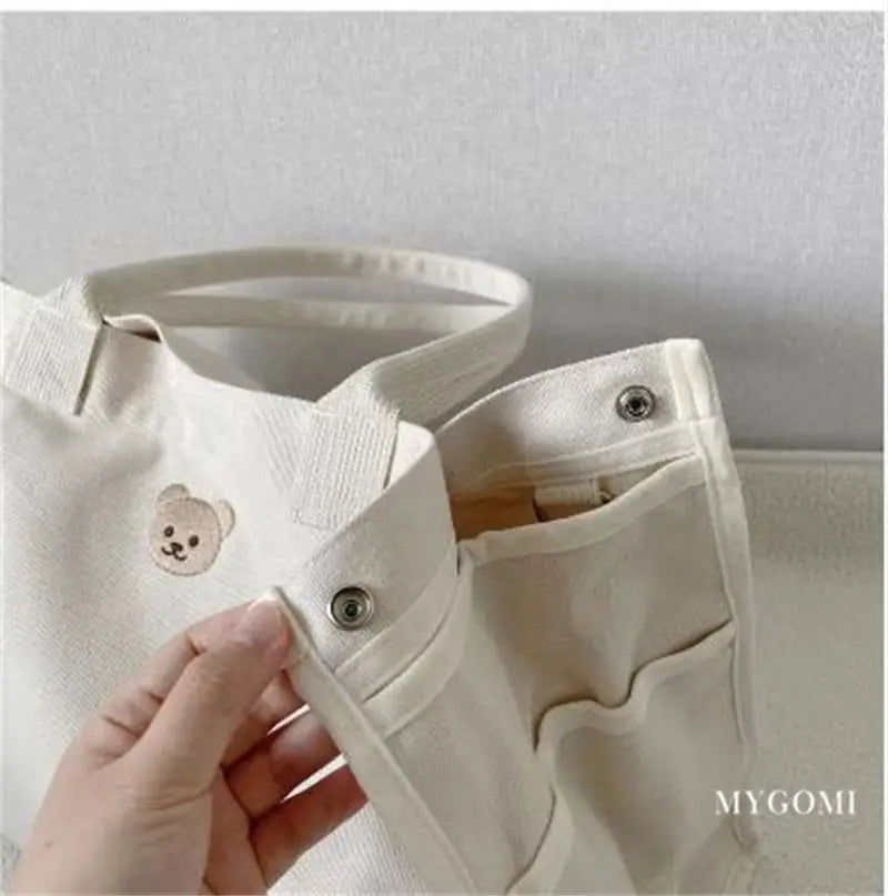 White canvas baby travel bag with a chic design, holding all critical baby items.