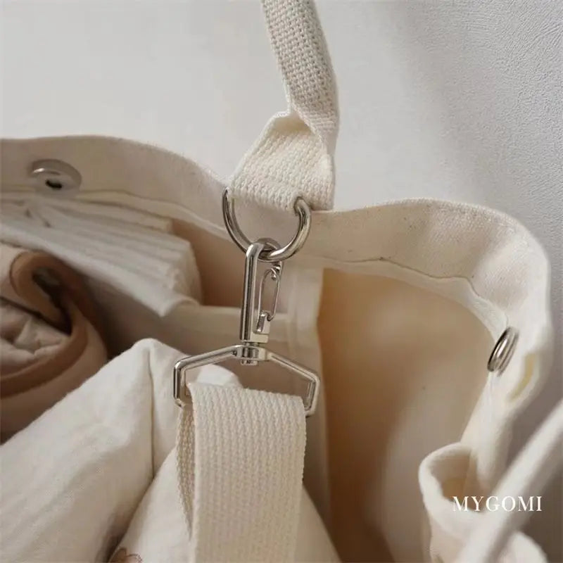 Elegant white canvas diaper bag, offering a blend of style and functionality for moms.