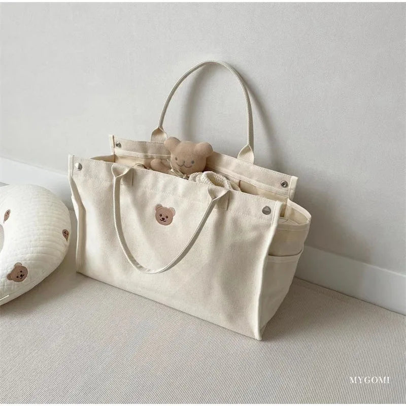 Top view of a white canvas diaper bag organizer, neatly packed with baby accessories.