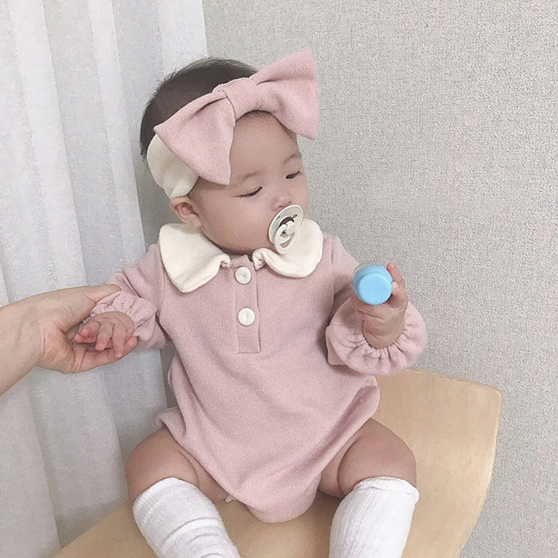 Stacked baby bodysuits, various colors, all with classic Peter Pan collars