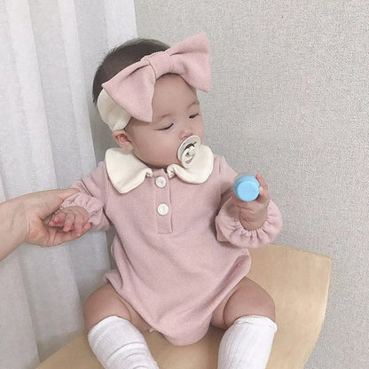 Stacked baby bodysuits, various colors, all with classic Peter Pan collars