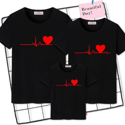 Dad and son wearing matching white 'Family Heartbeat' graphic t-shirts for a casual family outing.