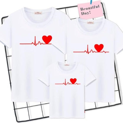 Close-up of a parent and child wearing 'Family Heartbeat' matching t-shirts, showcasing the graphic.