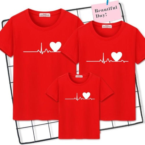 Happy family of four wearing 'Family Heartbeat' cotton blend matching t-shirts, great for photos.