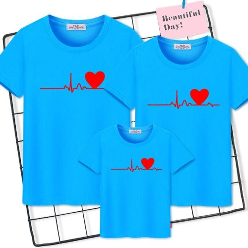 Parent and child in 'Family Heartbeat' graphic tees, a comfortable and stylish family matching outfit.
