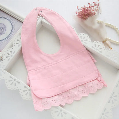 Infant girl wearing a stylish pink cotton lace baby bib, showcasing its comfortable fit and cute appearance.