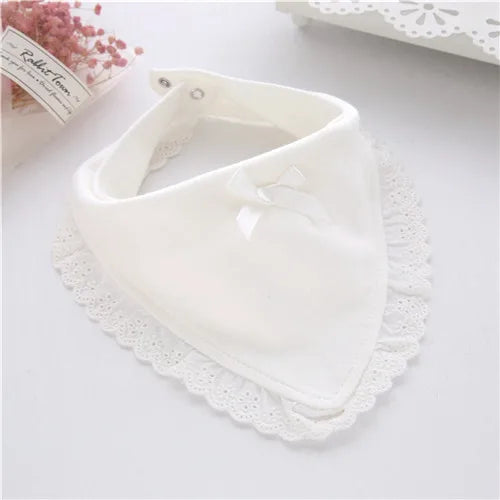 White cotton lace baby bib with a small bow detail, designed to be both fashionable and functional for infants.