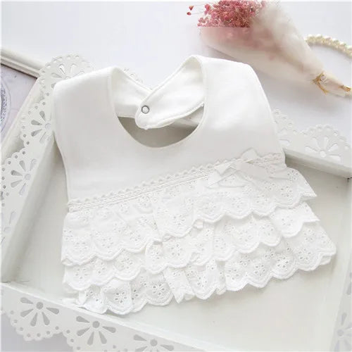 Close-up of the intricate lace border on a pink cotton baby bib, suitable for baby accessories.