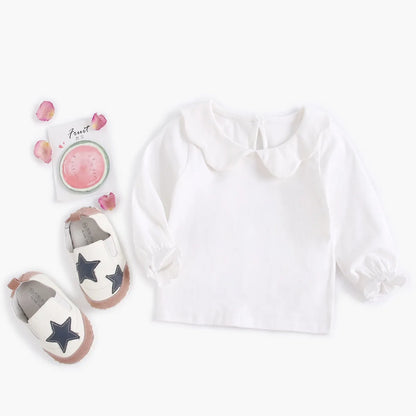 Close shot of the neckline of a white cotton baby fashion top for infants