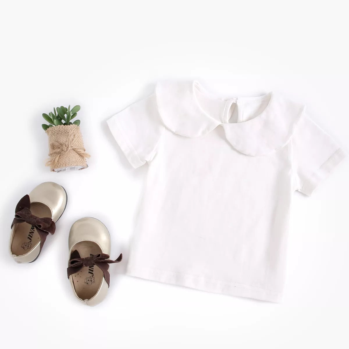 Newborn baby in a pure white cotton top, gentle and soft infant clothing