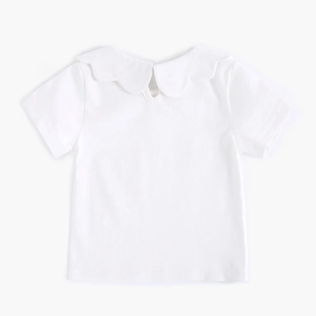 White cotton top for baby girls on light background, showcasing its softness