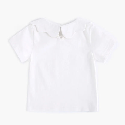 White cotton top for baby girls on light background, showcasing its softness