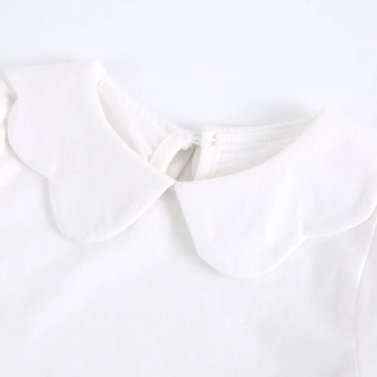 Toddler girl laughing in a comfortable white cotton short sleeve fashion top