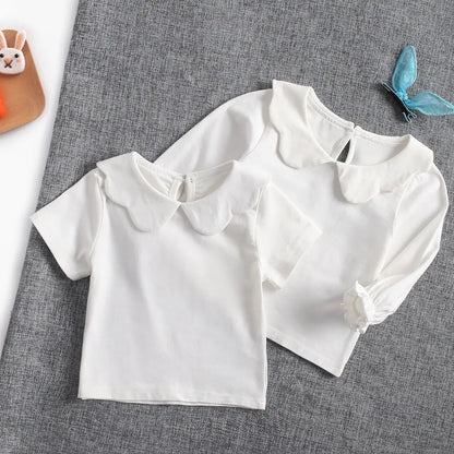 Toddler wearing a bright white cotton short sleeve top, comfortable infant fashion