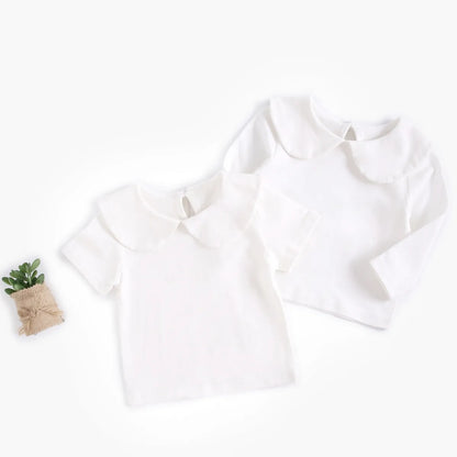White baby girl's cotton top on a hanger, ready for a spring summer outfit