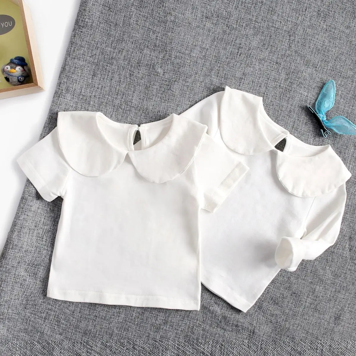 Folded white cotton fashion top for infants, essential baby boutique item