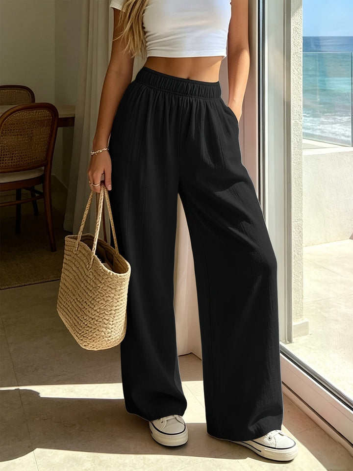 Beige women's wide leg drawstring pants. High waist, flowing fabric. Ideal for chic casual wear, beach or vacation.