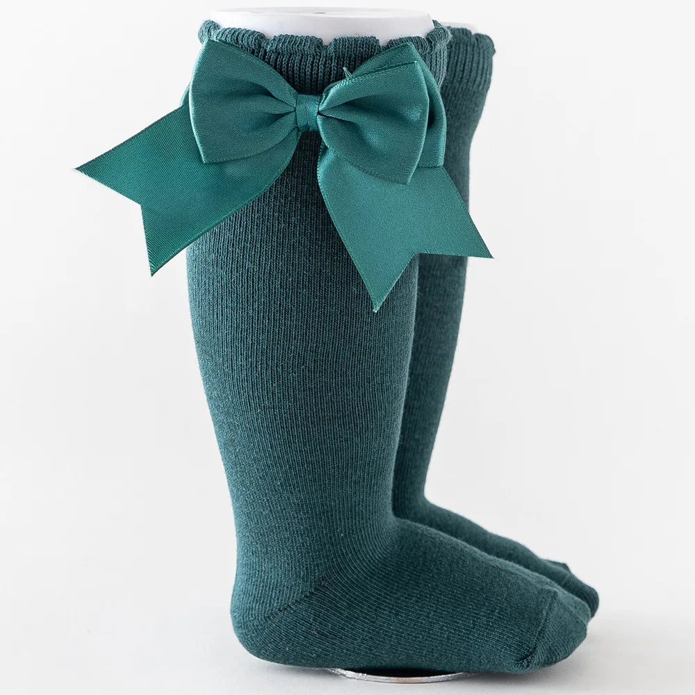 Black knee-high socks for girls, oversized red bow, stylish and warm for winter wear.