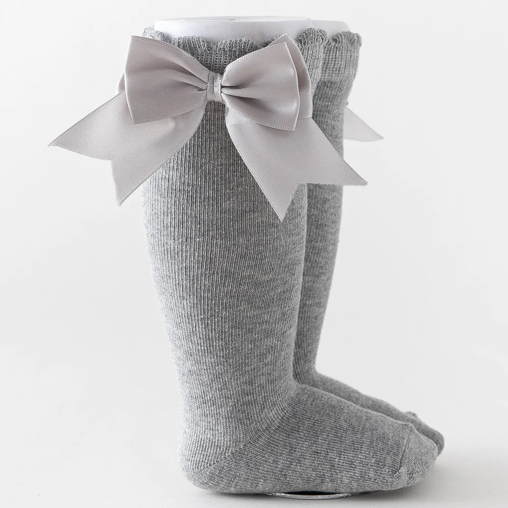 Green knee-high socks with a polka dot bow, unique kids fashion accessory for all ages.
