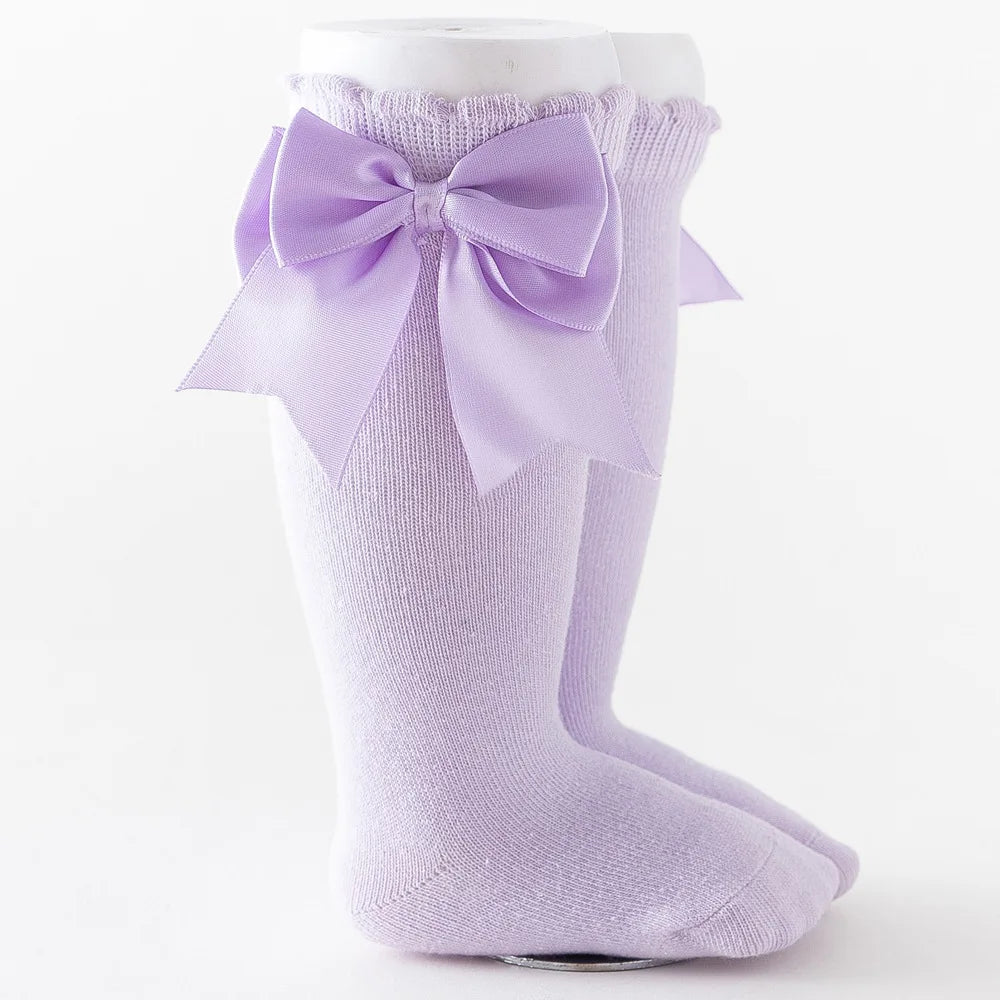 Light blue knee-high socks with a big fluffy white bow, soft and adorable for infants.