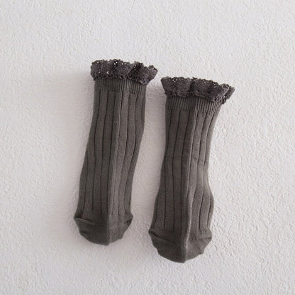 Close-up of white girls' lace frilly ankle socks, showing intricate lace and soft cotton texture