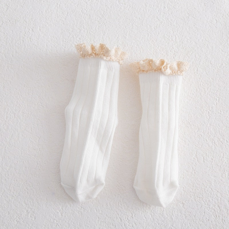 Toddler girl wearing white lace frilly ankle socks with Mary Jane shoes, showcasing cute style