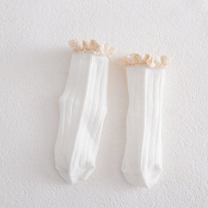 Toddler girl wearing white lace frilly ankle socks with Mary Jane shoes, showcasing cute style