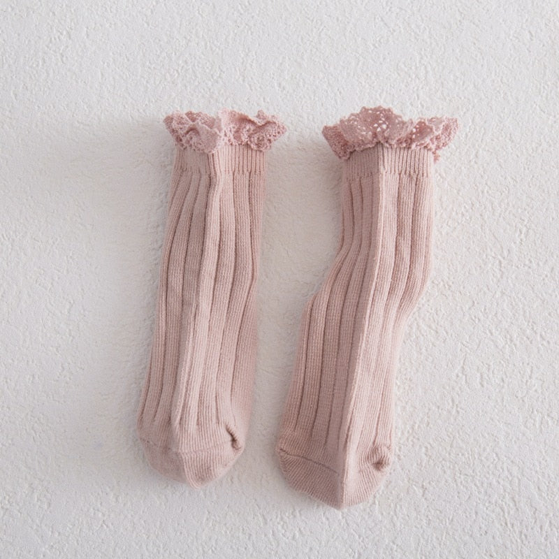 Girls' lace frilly ankle socks in a folded stack, gentle cotton material, various pastel colors